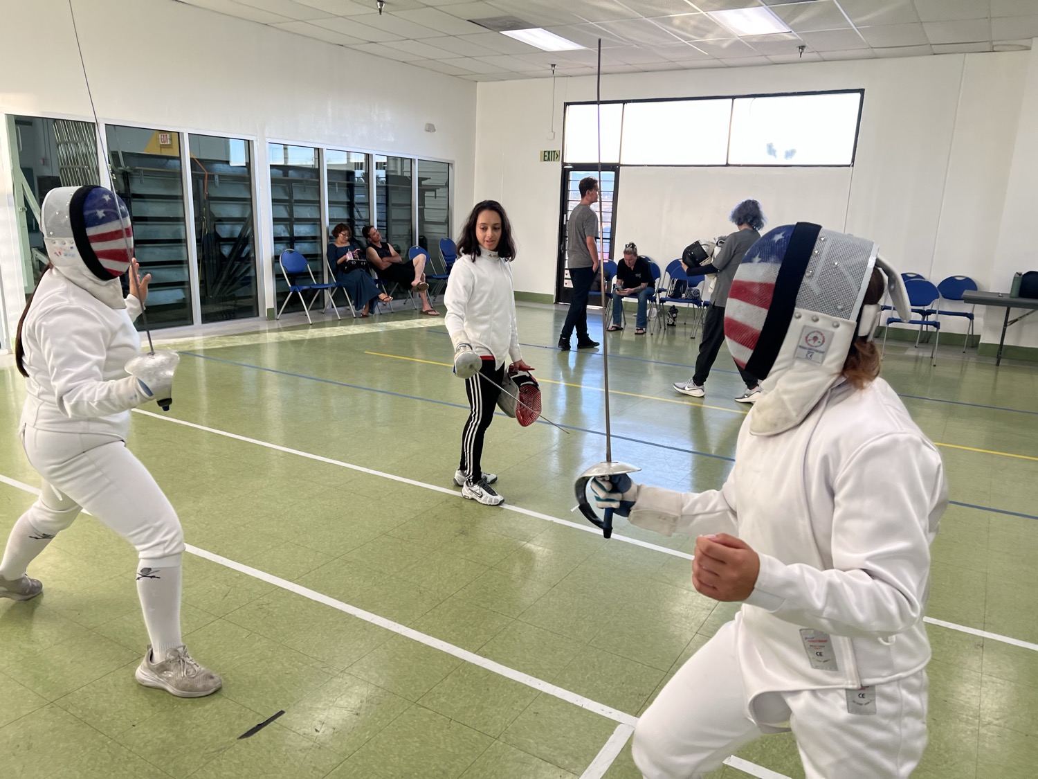 Fencers bouting in USA flag masks on the strip