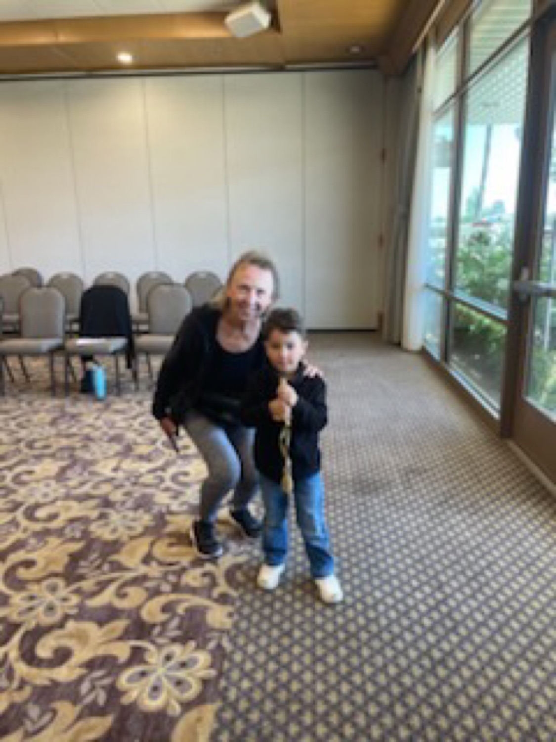 A coach and a young child holding a foil together