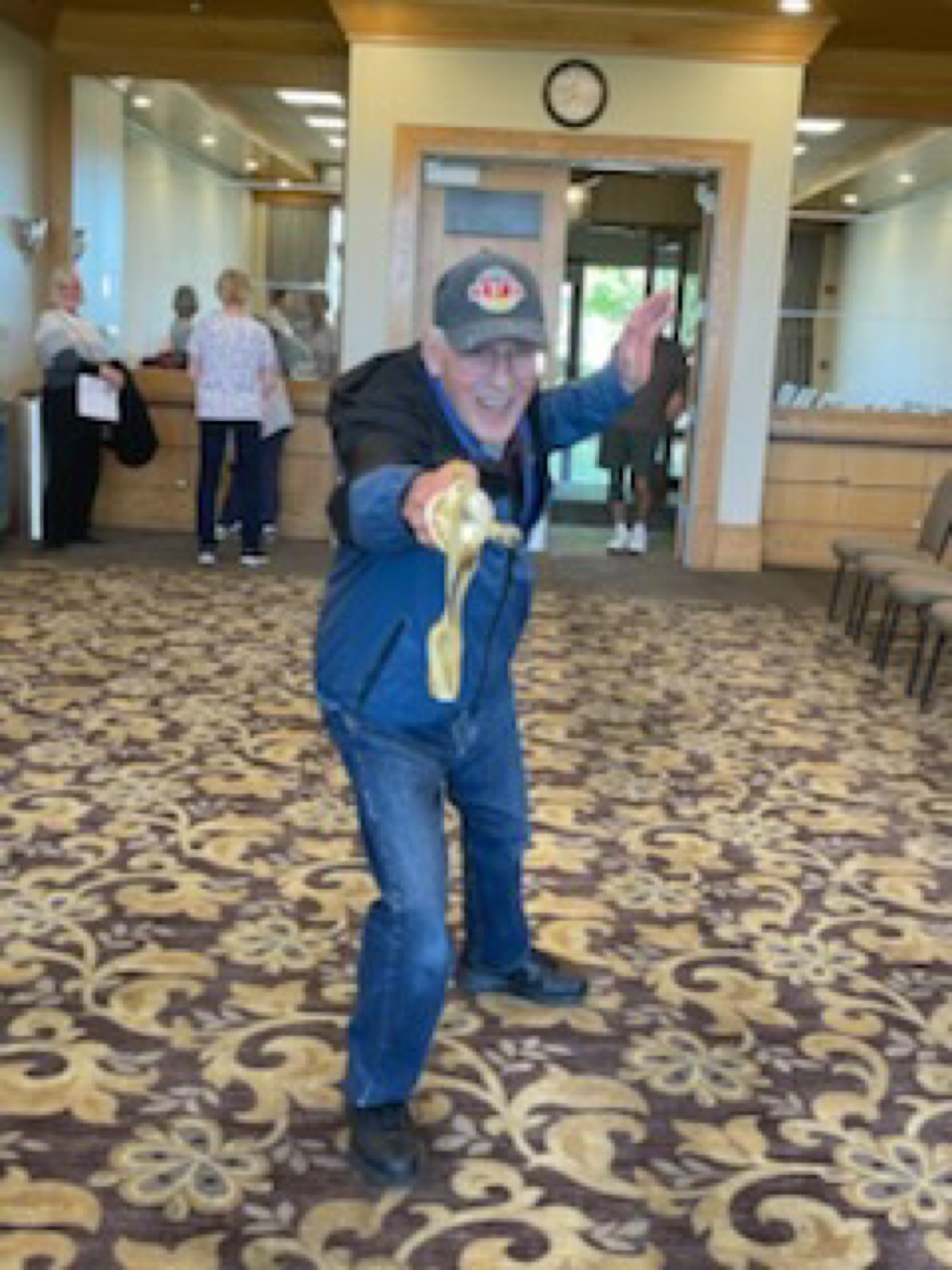 A smiling club member extending into a fencing lunge with a foil